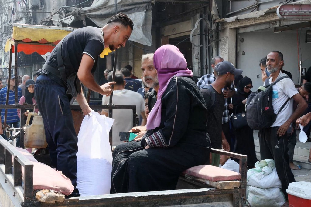 Umm Haytham Al-Kulak sits in a three-wheeled motorcycle trailer on her way back to her family.